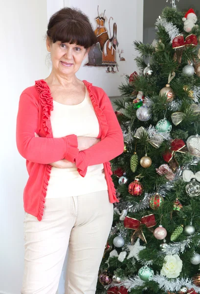 Edad madura mujer guapa contra de árbol de Navidad. Fondo de Navidad —  Fotos de Stock