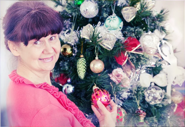 Mulher de boa aparência em idade madura contra a árvore de Natal. Fundo de Natal — Fotografia de Stock