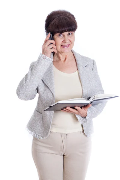 Mulher idosa falando ao telefone e posando como uma funcionária de escritório, administradora ou secretária. Retrato contra de fundo branco — Fotografia de Stock