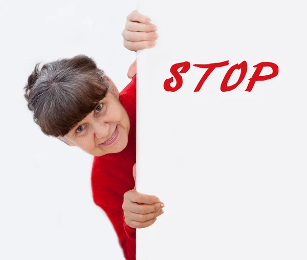 Mature woman leaning on white banner with Stop sign. Portrait against of white background — Stock Photo, Image