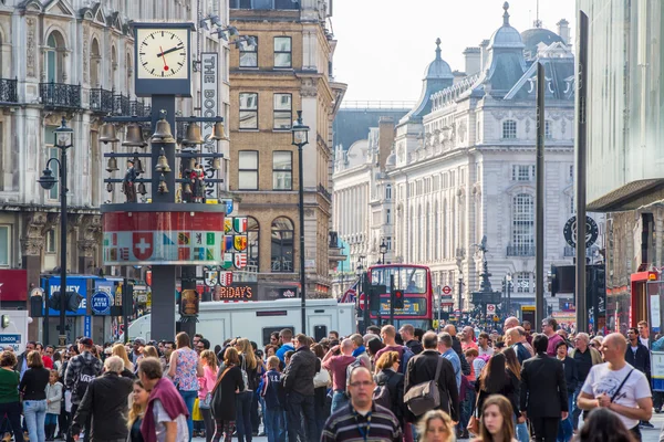 :Un sacco di persone, turisti e londinesi a piedi attraverso Leicester Square, la famosa destinazione di Londra per la vita notturna, cinema, ristoranti e bar — Foto Stock