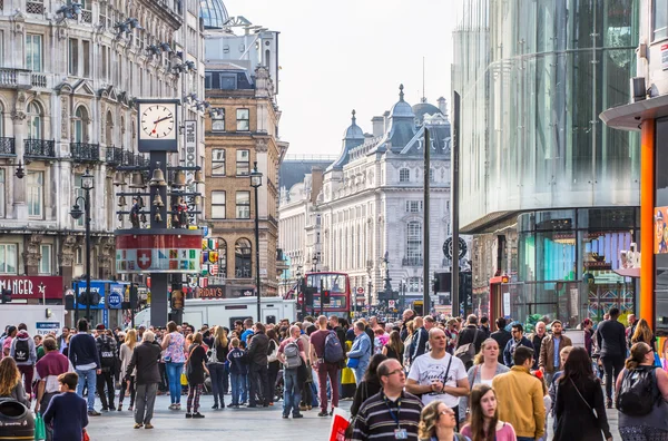 :Veel mensen, toeristen en Londenaren lopen via Leicester square, de bekende bestemming van Londen voor het nachtleven, bioscopen, restaurants en bars — Stockfoto