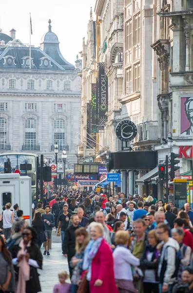 :Mucha gente, turistas y londinenses caminando a través de la plaza Leicester, el famoso destino de Londres para la vida nocturna, cines, restaurantes y bares —  Fotos de Stock