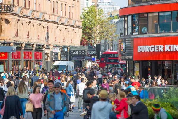 :Mucha gente, turistas y londinenses caminando a través de la plaza Leicester, el famoso destino de Londres para la vida nocturna, cines, restaurantes y bares — Foto de Stock