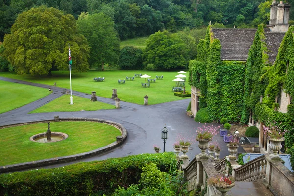 CHIPPENHAM, UK - AUGUST 9, 2014: Castle Combe, luxury house and gardens turned to be a hotel and golf club — Stock Photo, Image