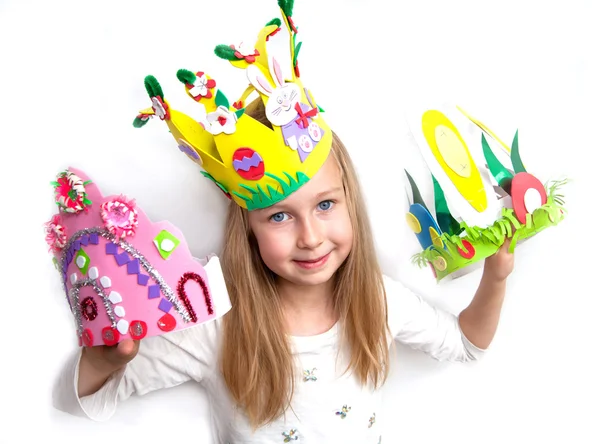 Liten flicka visar hennes hantverk verk och easter bonnet — Stockfoto