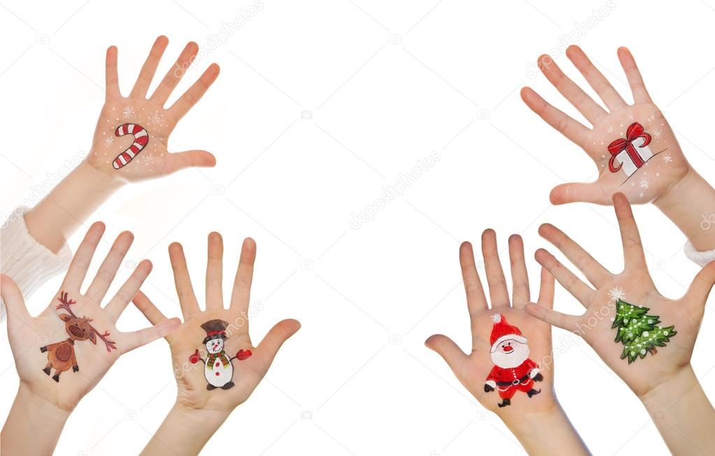 Children's hands raising up with painted Christmas symbols: Santa Claus, Christmas tree, Snow man, rain deer, present box