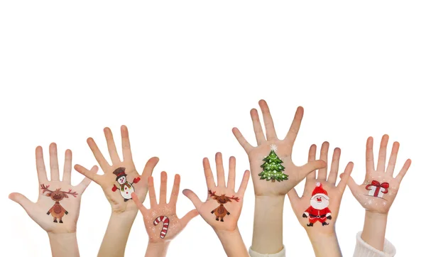 Mani dei bambini che si sollevano con simboli di Natale dipinti: Babbo Natale, Albero di Natale, Uomo delle nevi, Cervo della pioggia, Scatola regalo — Foto Stock