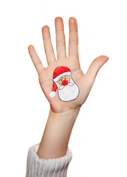 Παιδικά χέρια υψώνοντας με ζωγραφισμένα σύμβολα Χριστούγεννα: Άγιος Βασίλης, χριστουγεννιάτικο δέντρο, άνθρωπος χιόνι, βροχή ελάφια, παρόν πλαίσιο — Φωτογραφία Αρχείου