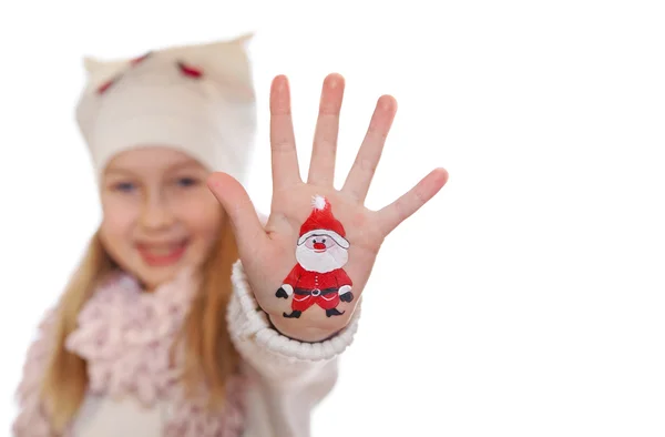 Fille heureuse démontrant des symboles de Noël peints sur ses mains. Père Noël, arbre de Noël, bonhomme de neige et etc. — Photo