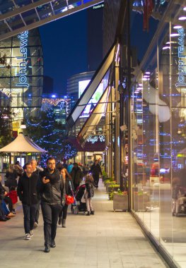 Stratford Köyü kare ve büyük alışveriş merkezi Noel ışıkları ve bir sürü insan çevresinde alışveriş süslenmiş