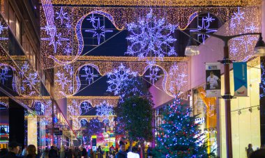 Stratford Köyü kare ve büyük alışveriş merkezi Noel ışıkları ve bir sürü insan çevresinde alışveriş süslenmiş