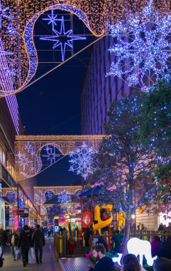 Stratford Köyü kare ve büyük alışveriş merkezi Noel ışıkları ve bir sürü insan çevresinde alışveriş süslenmiş