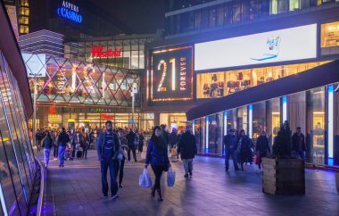 Stratford Köyü kare ve büyük alışveriş merkezi Noel ışıkları ve bir sürü insan çevresinde alışveriş süslenmiş