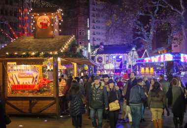 London, Leicester square traditional fun fair with stools, carrousel, prises to win and Christmas activity. People and families enjoying Christmas mood night out clipart