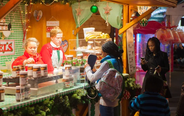 London, Leicester square traditionella Tivoli med avföring, carrousel, balansering att vinna och jul aktivitet. Människor och familjer som njuter av julen humör utekväll — Stockfoto