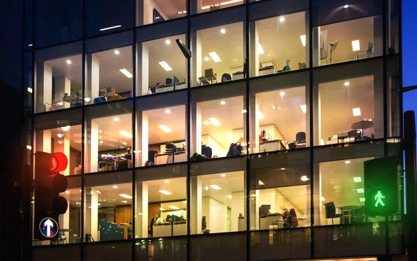 London, Office block with lots of lit up windows and late office workers inside. City of London business aria in dusk. — Stock Photo, Image