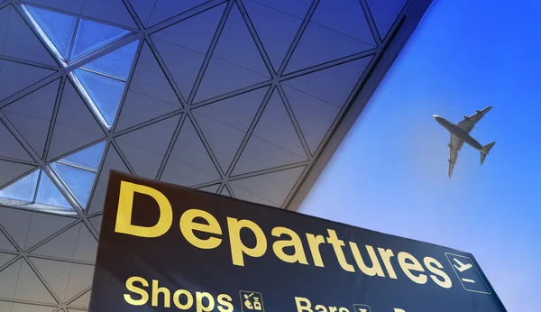 Departure sign and airplane in the blue sky — Stock Photo, Image