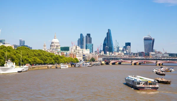 LONDRES, Reino Unido - 22 JULIO 2014: Vista de la ciudad de Londres desde el puente de Londres. Catedral de San Pablo, banco de jalá, Gherkin, edificio Walkie Talkie y barcos de paso en el río Támesis — Foto de Stock