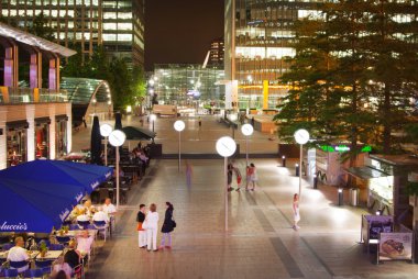 Canary Wharf square view in night lights with office workers chilling out after working day in local cafes and pubs. London clipart