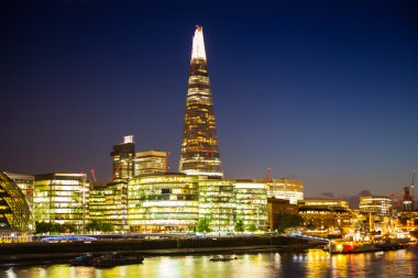 Londra, İngiltere - 11 Ağustos 2014: Güney yürüyüşü gece ışıkları Thames Nehri. Londra'nın salonu ve cam parçası modern binalar görünümü içerir