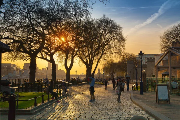 LONDRA, Regno Unito - 15 APRILE 2015: Parco delle torri al tramonto. Fiume Tamigi passeggiata laterale con le persone che riposano vicino all'acqua — Foto Stock