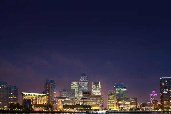 London, Canary Wharf in night with lights reflection in Thames water — Stock fotografie