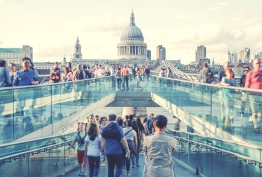 LONDON, UK - MARCH 29, 2014: South bank walk of the river Thames. View on St. Paul's cathedral from foot bridge