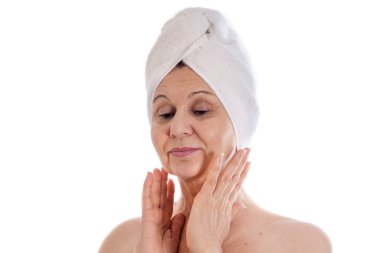 Spa kavramı. Başında beyaz havlu ile iyi görünümlü kadın yaşlı