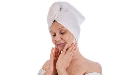 Spa kavramı. Başında beyaz havlu ile iyi görünümlü kadın yaşlı