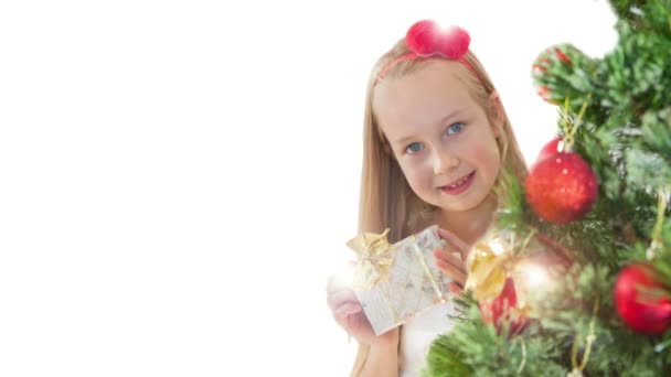 Lycklig liten flicka med nuvarande bakom julgran — Stockvideo