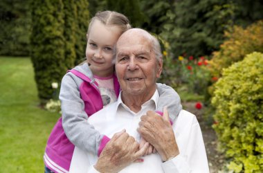95 years old english man with granddaughter in garden clipart