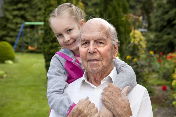 95 years old english man with granddaughter in garden