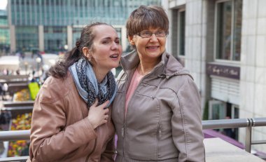 Aile portresi açık emeklilik yaş anne ve kızı gülen ve etrafa şehir. İki nesil, mutluluk ve bakım kavramı