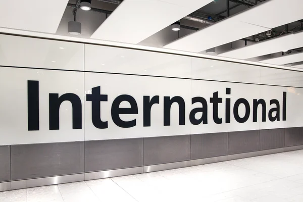 LONDON, UK - MARCH 28, 2015: International arrivals sign. Interior of  Heathrow airport Terminal 5. New building — ストック写真