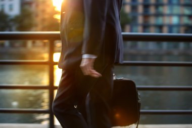 Business man in suit walking against of sunset light, London