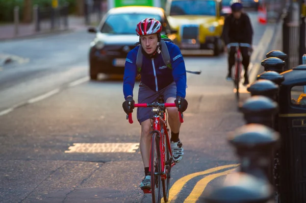 London, UK - 7. September 2015: Londoner, die mit dem Fahrrad von der Arbeit kommen. Straßenansicht mit Autos und Radfahrern — Stockfoto