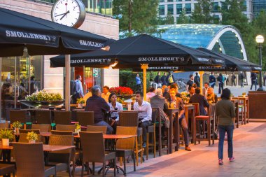 LONDON, UK - 7 SEPTEMBER, 2015: Canary Wharf night life. People sitting in local restaurant after long hours working day