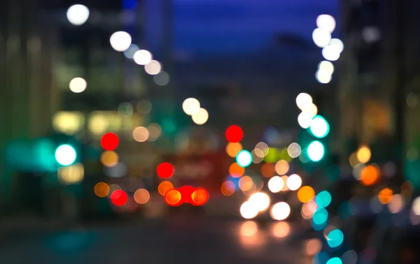 Las luces de la ciudad difuminan el fondo. Londres, Canary Wharf vida nocturna. Tráfico, carreteras, faroles y edificios de oficinas iluminados — Foto de Stock