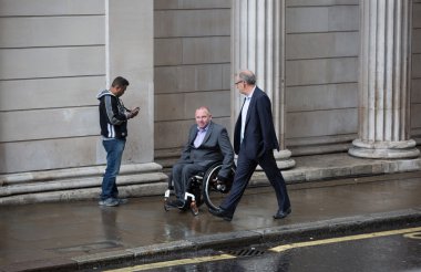 LONDON, UK - SEPTEMBER 17, 2015: Two businessmen walking on the street against of Bank of England wall