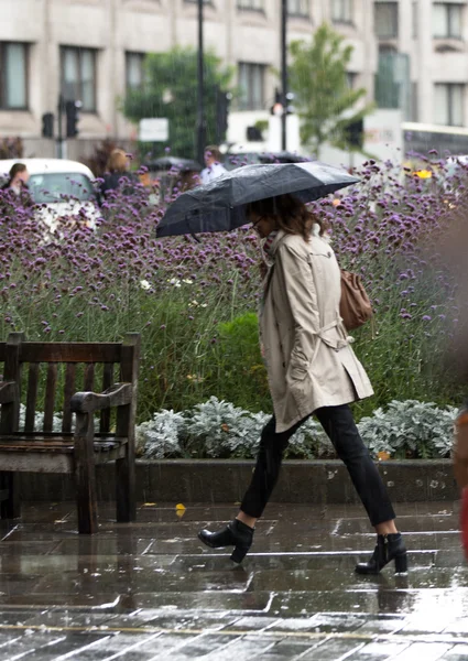 Londra, İngiltere - 17 Eylül 2015: Kadınla şemsiye yağmur altında yürümek. Londra şehri — Stok fotoğraf