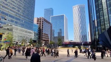 Londra, İngiltere - 7 Ekim 2025: Canary Wharf Meydanı 'nda öğle yemeği vakti yürüyen insanlar. Güneşli bir günde gökdelenlerin ve ofis binalarının güzel manzarası.