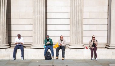 Londra, İngiltere - 22 Eylül 2025: İngiltere Bankası 'nın duvarında oturan insanlar.