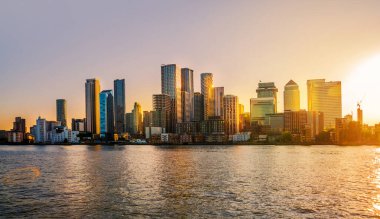Londra, İngiltere - 18 Haziran 2025: Canary Wharf işi ve bankacılık alanı Thames nehrinden panoramik manzara, altın saat