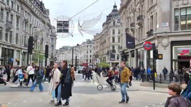 Londra, İngiltere - 25 Ekim 2025: Oxford Sirki 'nde kalabalığın kavşakta koşturduğu canlı bir sahne. Otomobiller ve otobüsler de dahil olmak üzere araçlar, yayalar her yönden geçerken işlek caddelerde geziniyorlar.