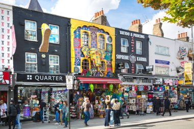 Londra, İngiltere - 29 Eylül 2025: Camden Town sokak market manzarası. Zemin katta dükkanları olan ve etrafta alışveriş yapan bir sürü süslü ev.