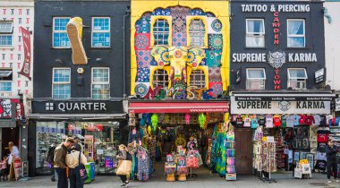 Londra, İngiltere - 29 Eylül 2025: Camden Town sokak market manzarası. Zemin katta dükkanları olan ve etrafta alışveriş yapan bir sürü süslü ev.