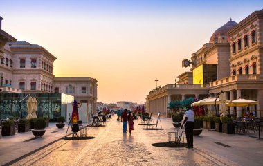 Katar, Doha - 6 Eylül 2025: Gün batımında Plaza alışveriş merkezi ve yürüyen insanlar