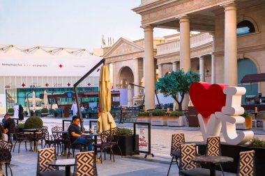 Katar, Doha - 6 Eylül 2025: Gün batımında Plaza alışveriş merkezi ve yürüyen insanlar