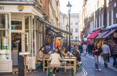 Londra, İngiltere - 25 Eylül 2025: Batı Yakası 'nda halk evi girişi ve dışarıda içen insanlar